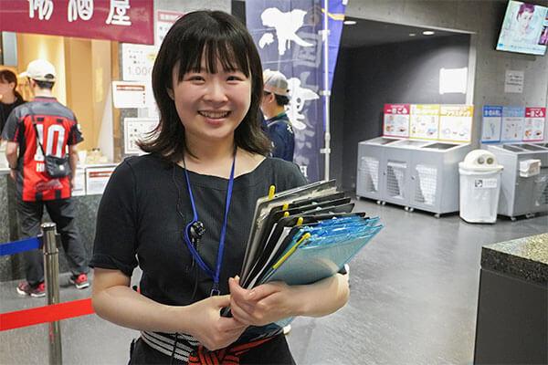 売店前でほほ笑む社員の写真