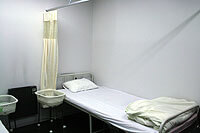 仕切りカーテンのついたベッドが並ぶ医務室